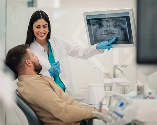 Dentist pointing to a patient's x-rays during their visit