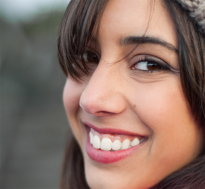 Young brunette woman smiling after gum disease treatment in North Dallas