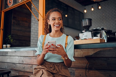 Smiling woman sitting on barstool at restaurant