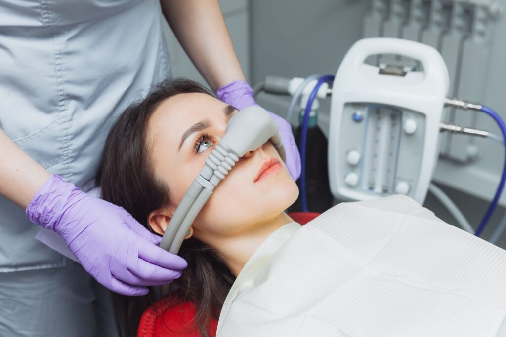 Dentist placing nitrous oxide mask over patient's nose